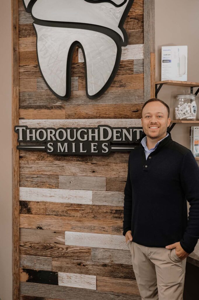 image of Dr. Smith standing beside the logo of thoroughdent smiles