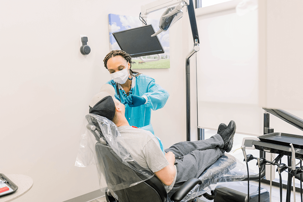 assistant working on a patient in dental chair